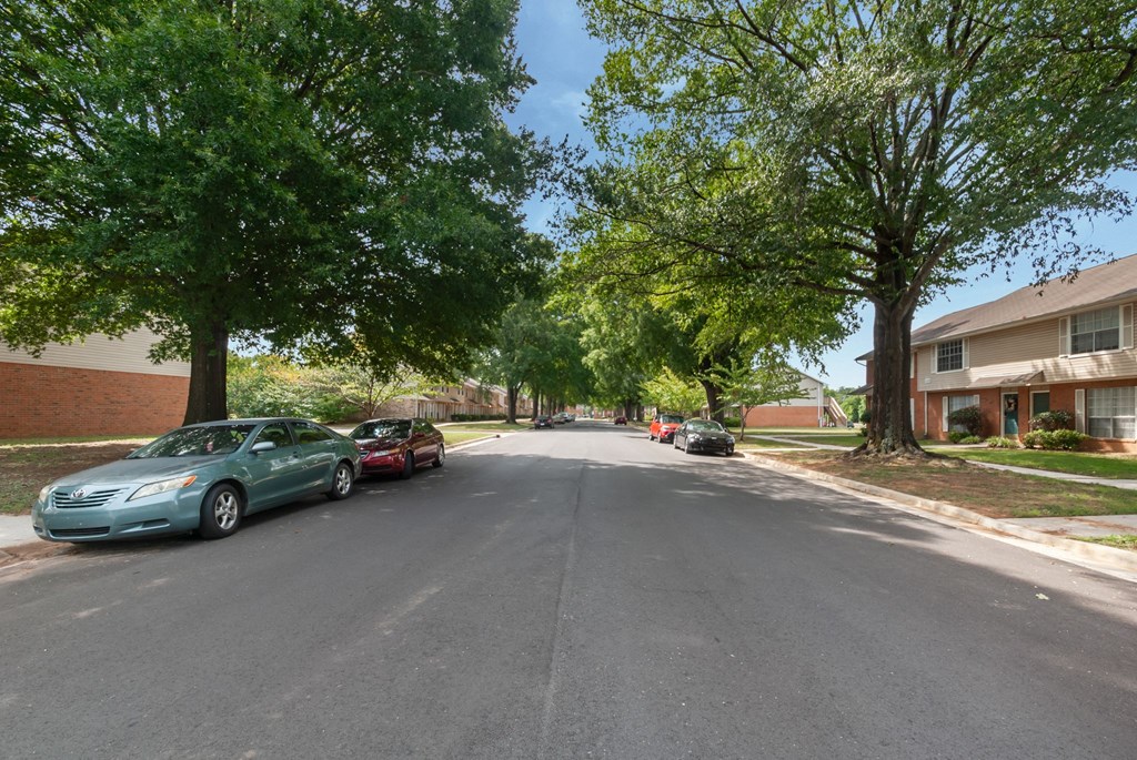 A street with cars and trees on both sides.