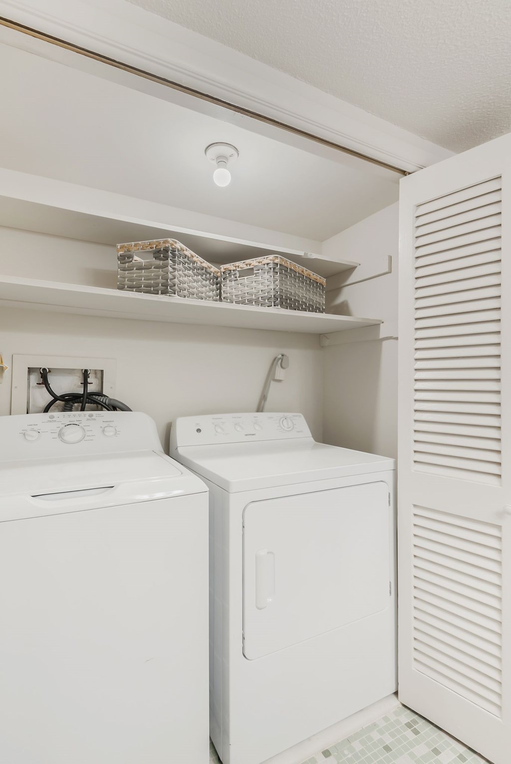 A white washing machine and dryer in a small laundry room.