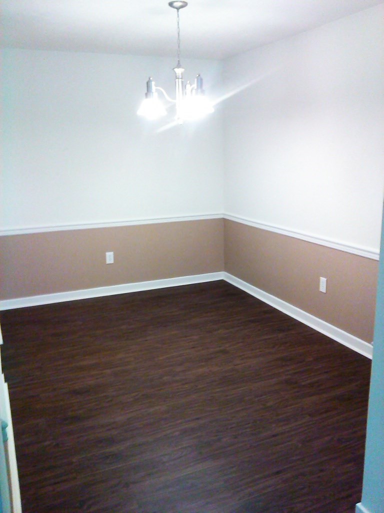 an empty room with wood floors and white walls