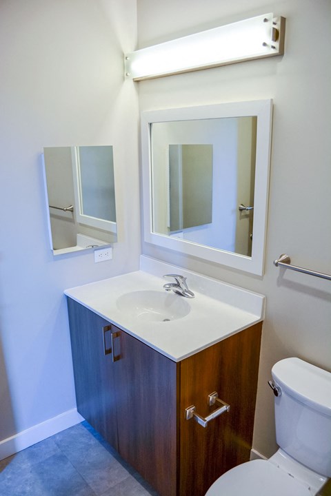 A bathroom with a sink, mirror, and toilet.