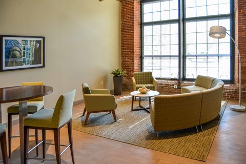 A living room with a yellow chair and a brown couch.