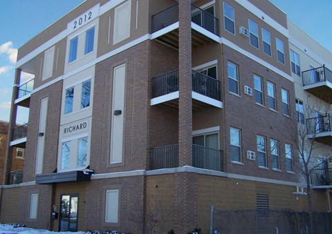 a brick apartment building with balconies in the snow