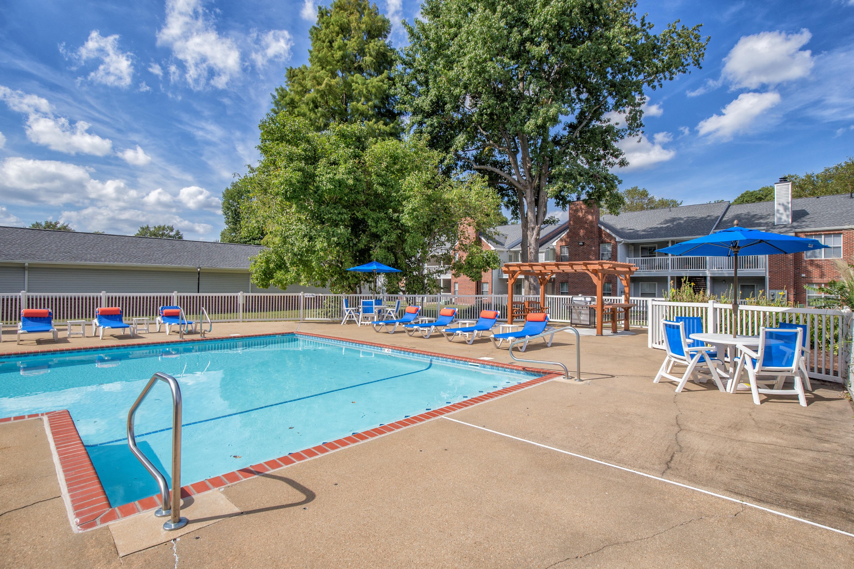 Large pool with sunbathing chairs and tables at St. Croix Apartments in Virginia Beach VA