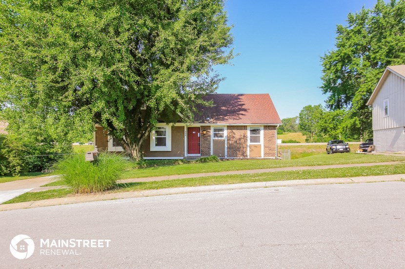 a small brick house on the corner of a street