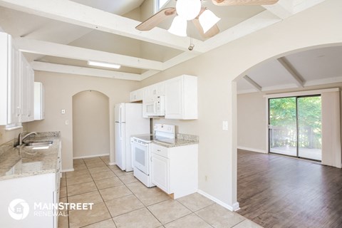 a kitchen with white cabinets and a sink and a refrigerator