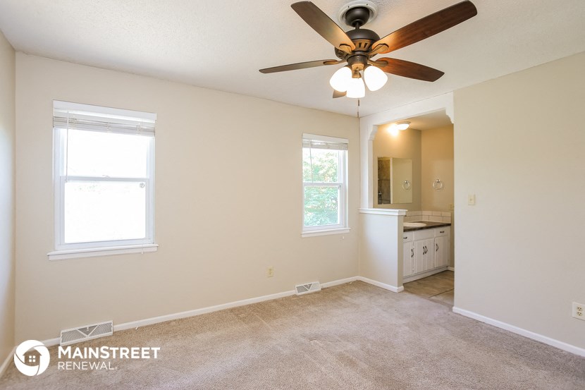 the master bedroom has a ceiling fan and carpeted flooring