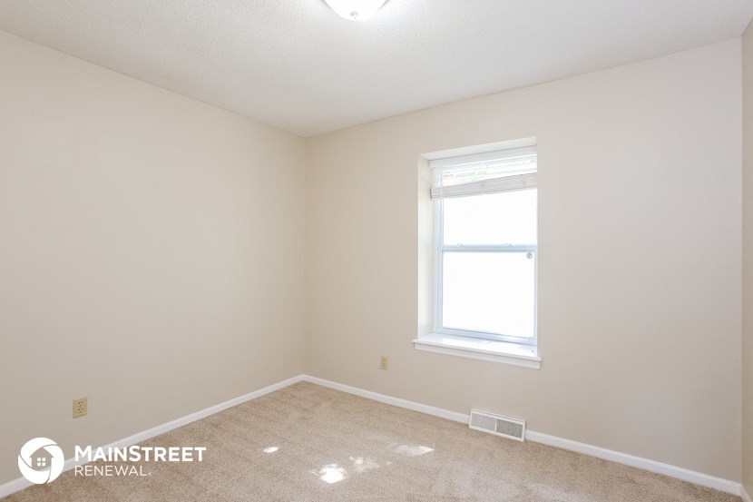 the interior of a room with a window and carpet