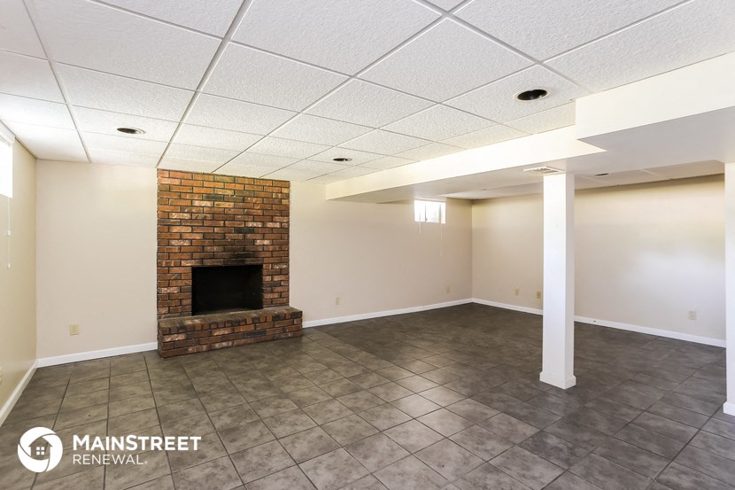 an empty room with a fireplace and tile flooring