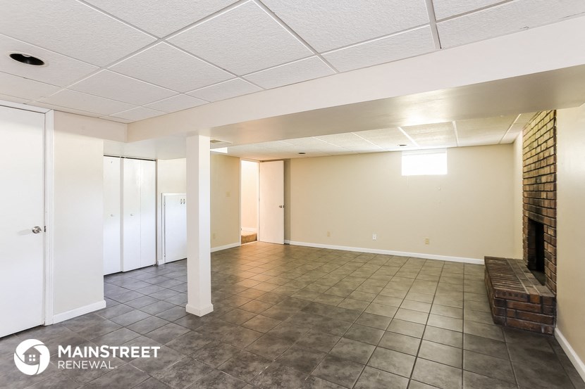 an empty living room with tile floors and white walls