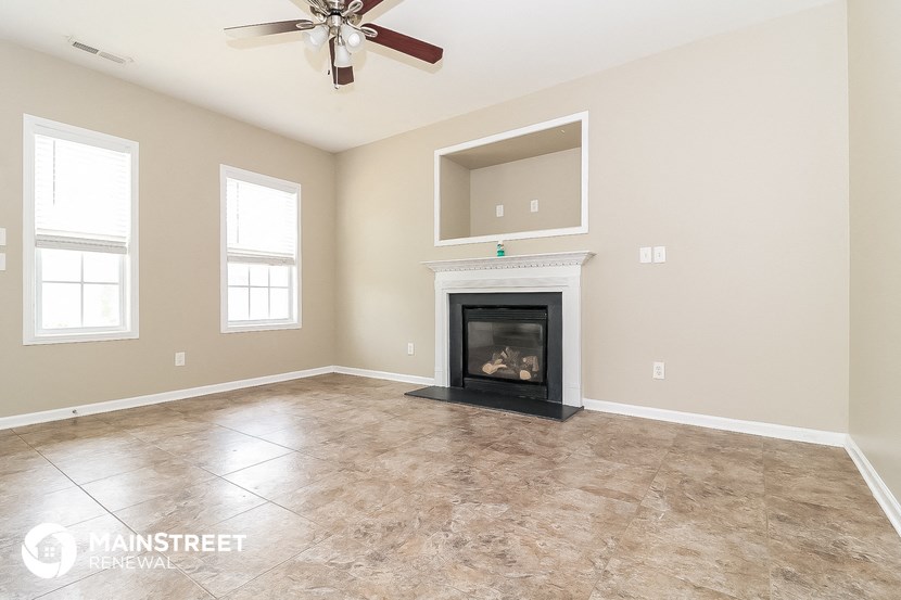 the living room has a fireplace and tile flooring