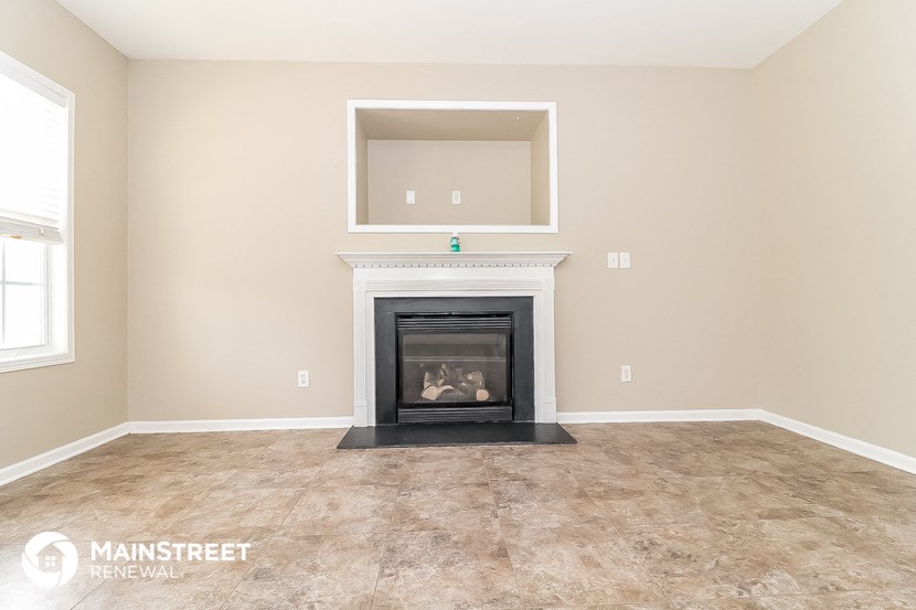 the living room of this home has a fireplace and a window
