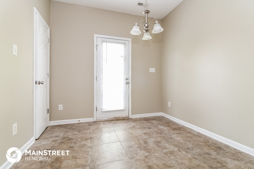 a empty living room with a door and a window