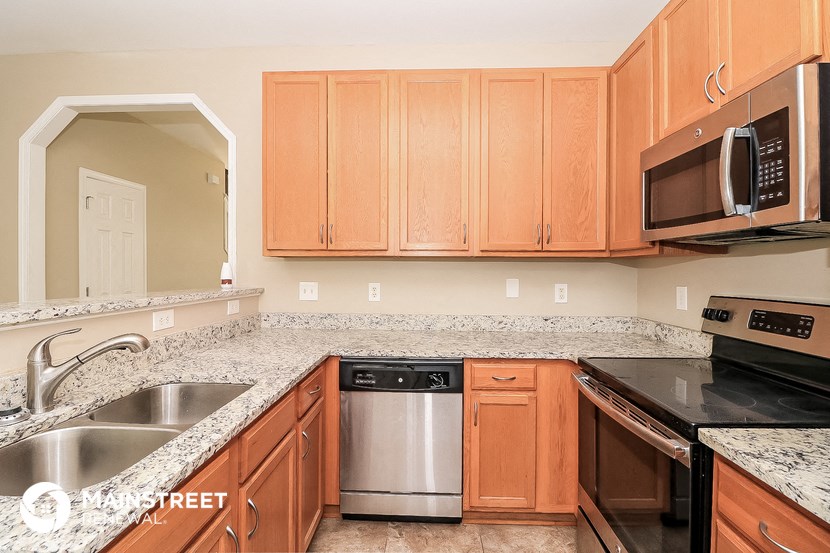 a kitchen with granite counter tops and wooden cabinets