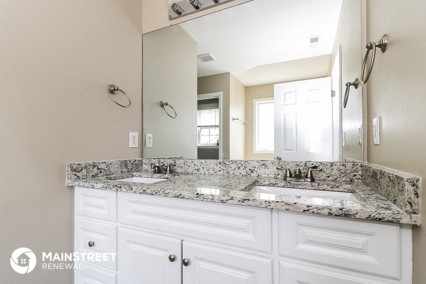 a bathroom with two sinks and a large mirror