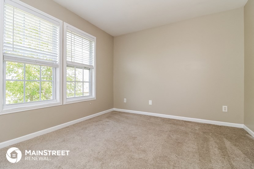 the master bedroom has a carpeted floor and two windows