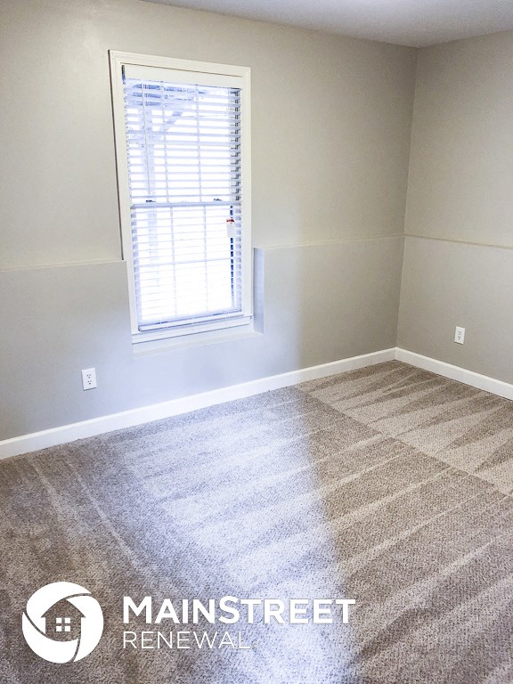 a room with a carpeted floor and a window