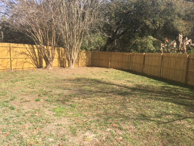 a backyard with a wooden fence and some trees