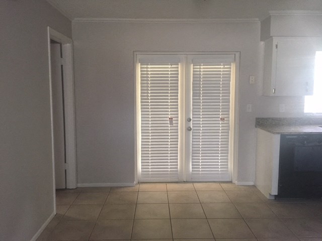 a kitchen with white doors and a tiled floor