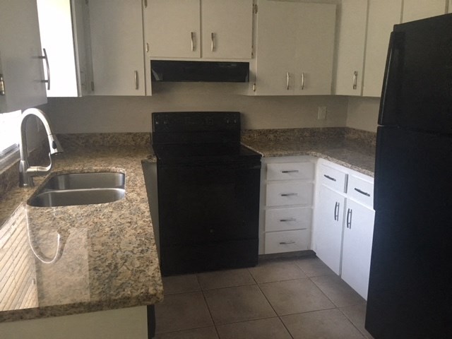 a kitchen with a black stove and a sink