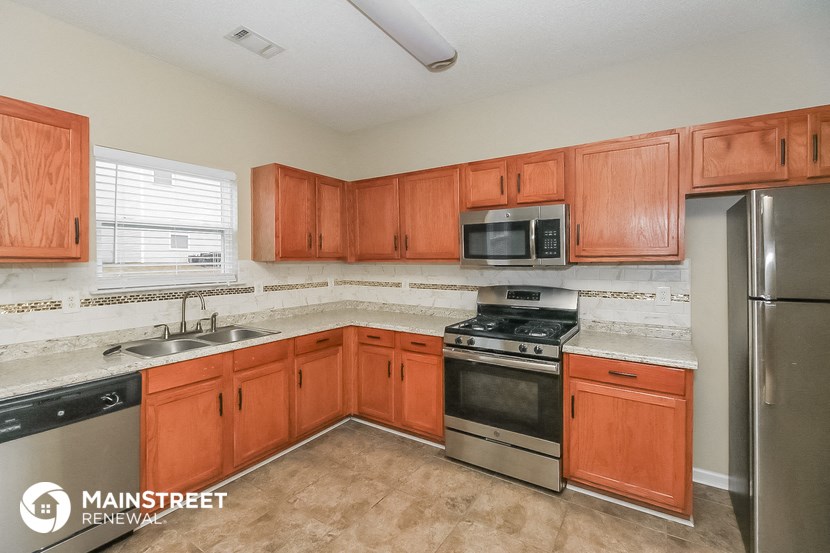 a kitchen with wooden cabinets and stainless steel appliances