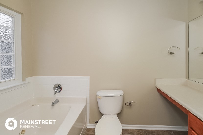 a bathroom with a toilet and a tub and a sink