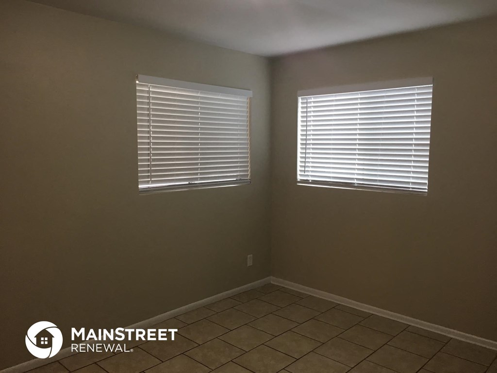 a room with two windows and a tiled floor