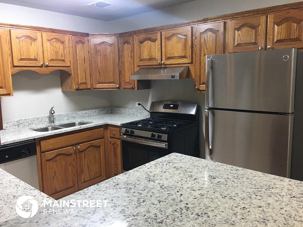 a kitchen with wooden cabinets and stainless steel appliances