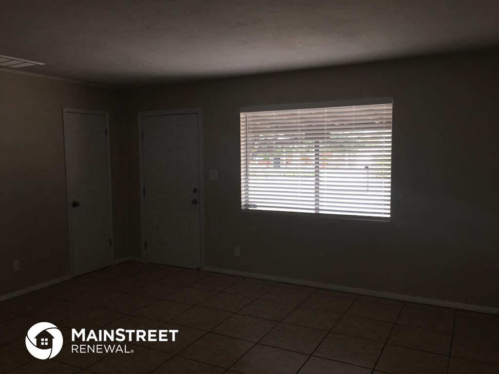 an empty room with a window and a door