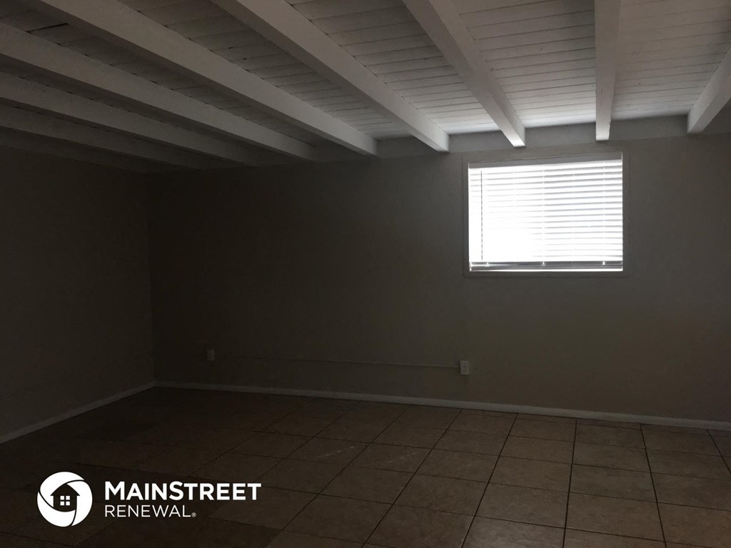 a dark room with a window and a tiled floor