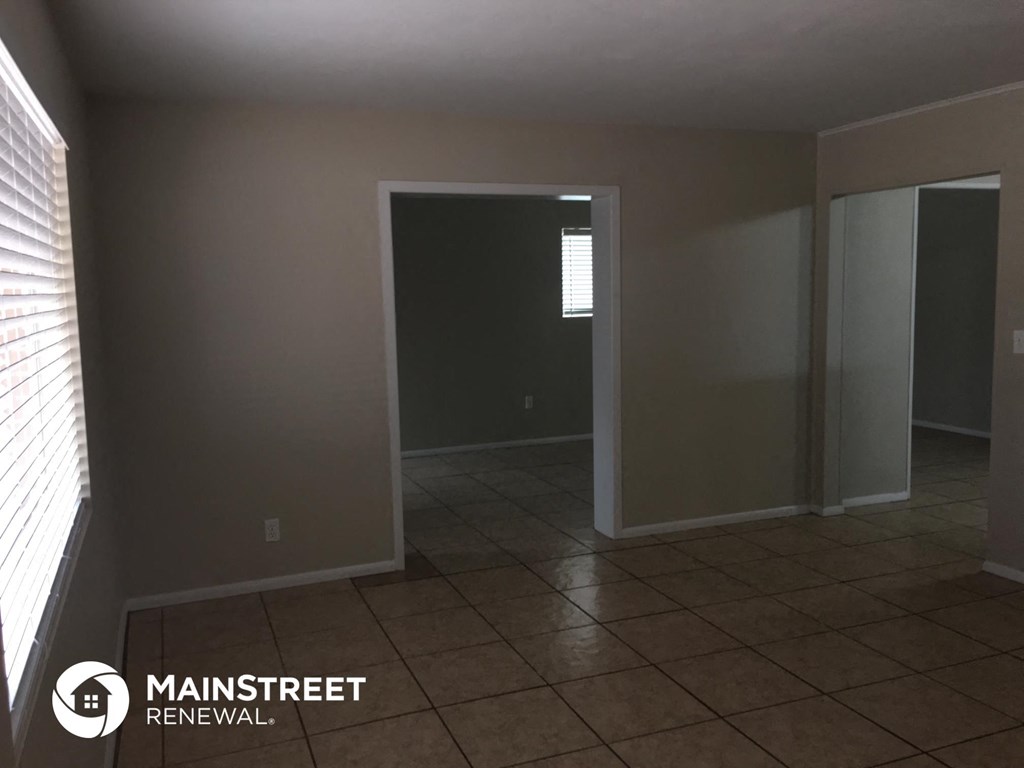 an empty room with an open door and a tiled floor