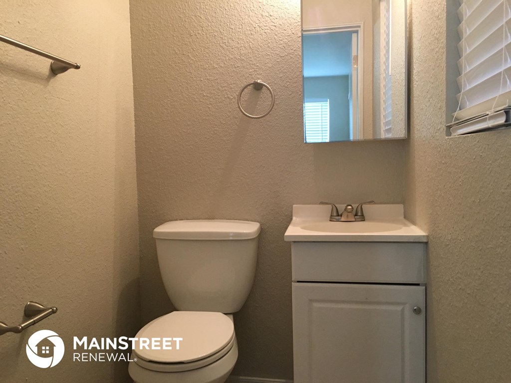 a bathroom with a toilet and a sink and a mirror