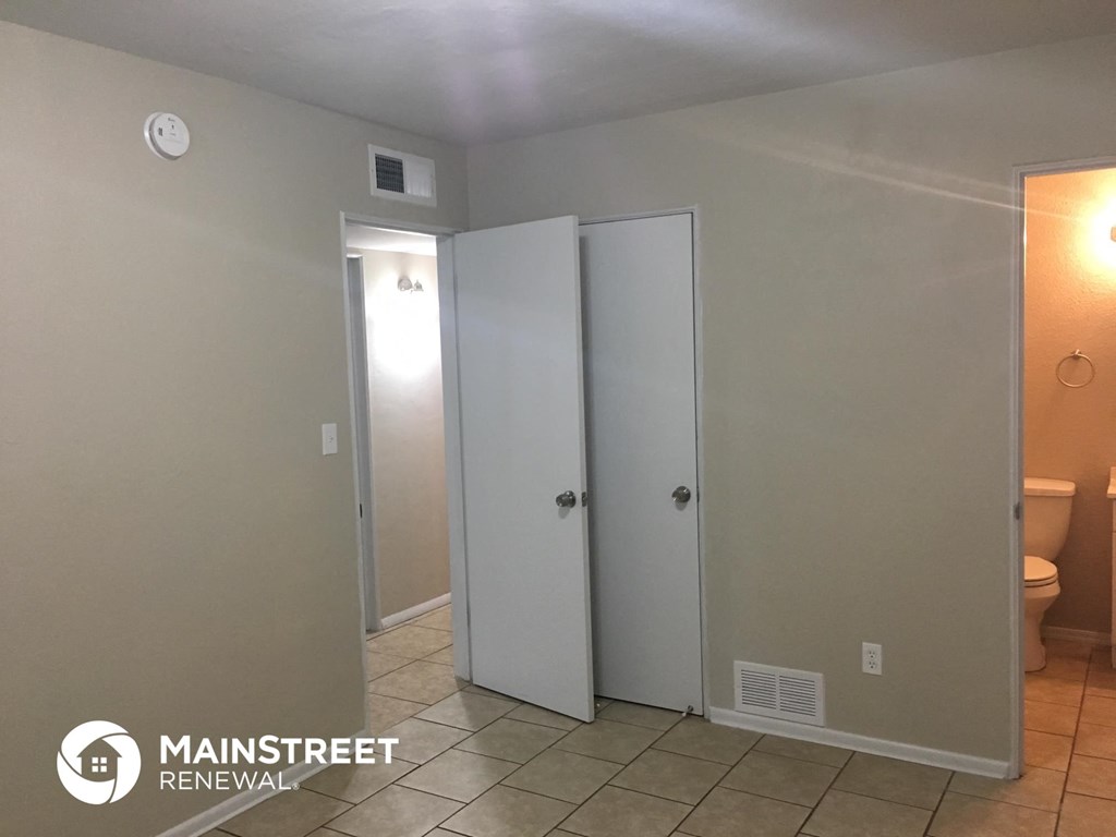 a bathroom with a toilet and two closets