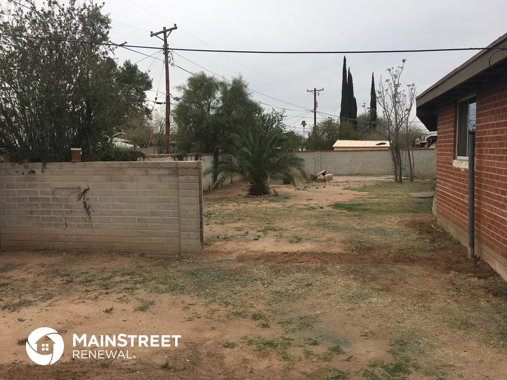 a backyard with a brick fence and a brick retaining wall