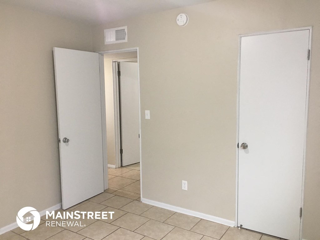 a bathroom with two white doors and a tiled floor
