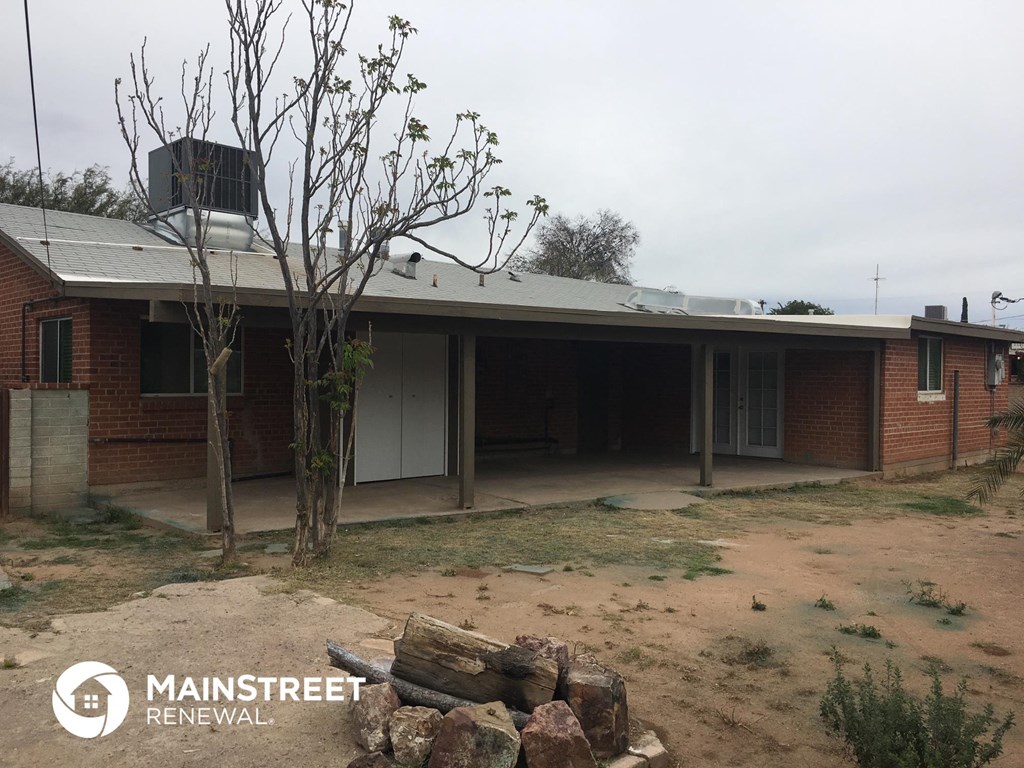 a house with a yard and a tree in front of it
