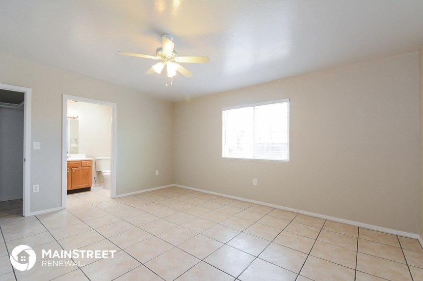 an empty living room with a ceiling fan