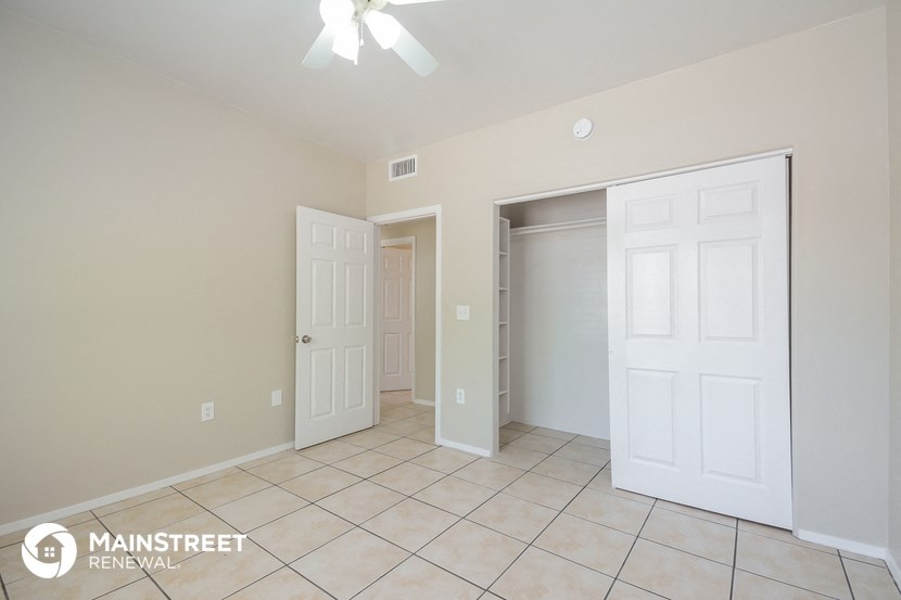 a master bedroom with two closets and a tiled floor