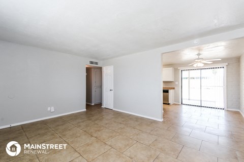 the spacious living room with tile flooring and a door to the kitchen