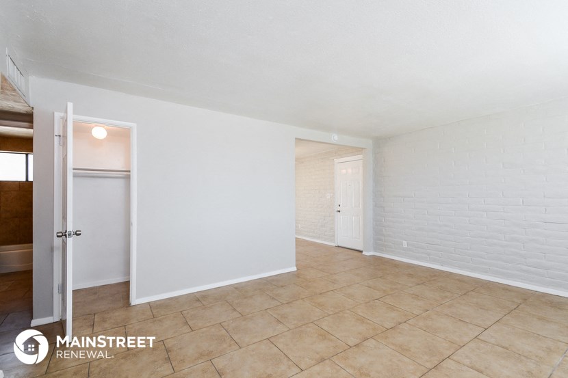 the living room and dining room with white brick walls and tile flooring