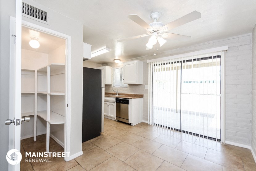 a kitchen with a ceiling fan and a door to a closet