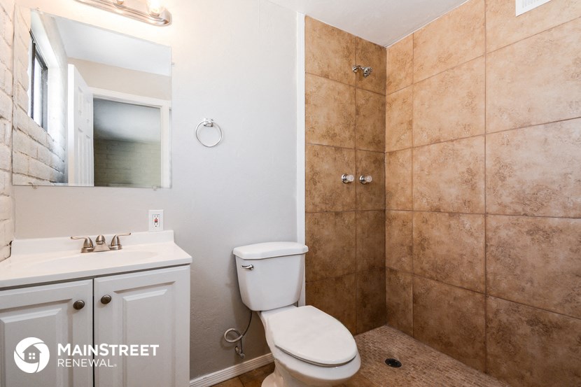 a bathroom with a toilet and a sink and a mirror