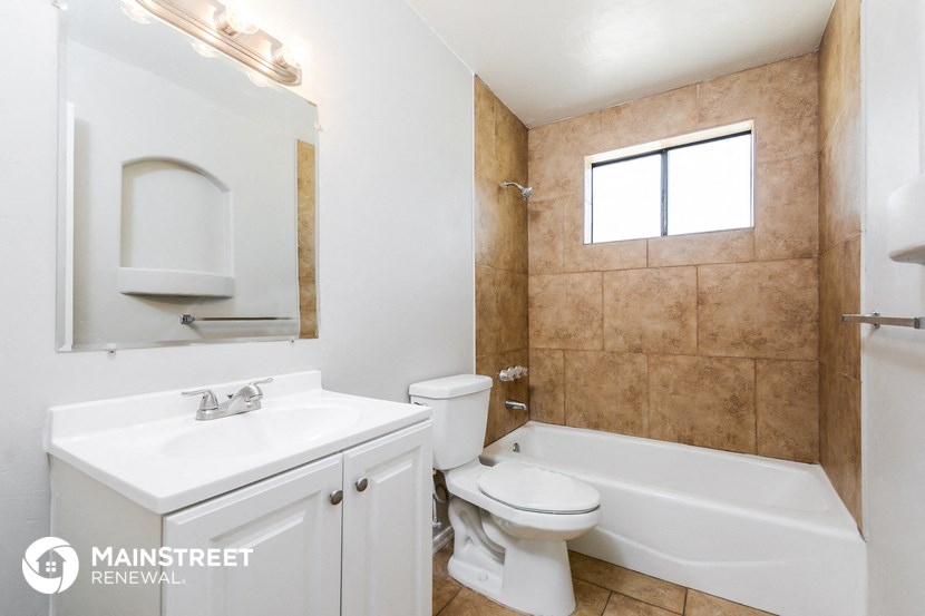 a bathroom with a toilet sink and a tub and a mirror
