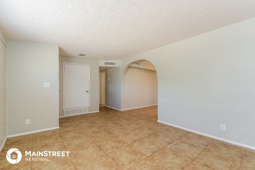 the living room and dining room of an empty house