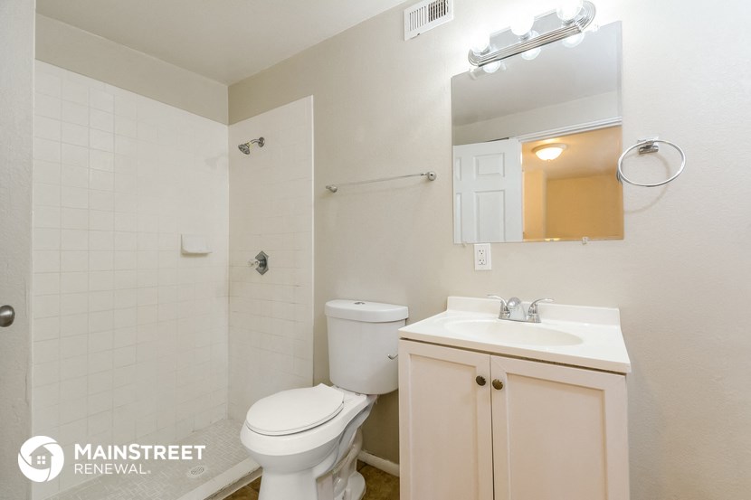 a bathroom with a toilet and a sink and a mirror