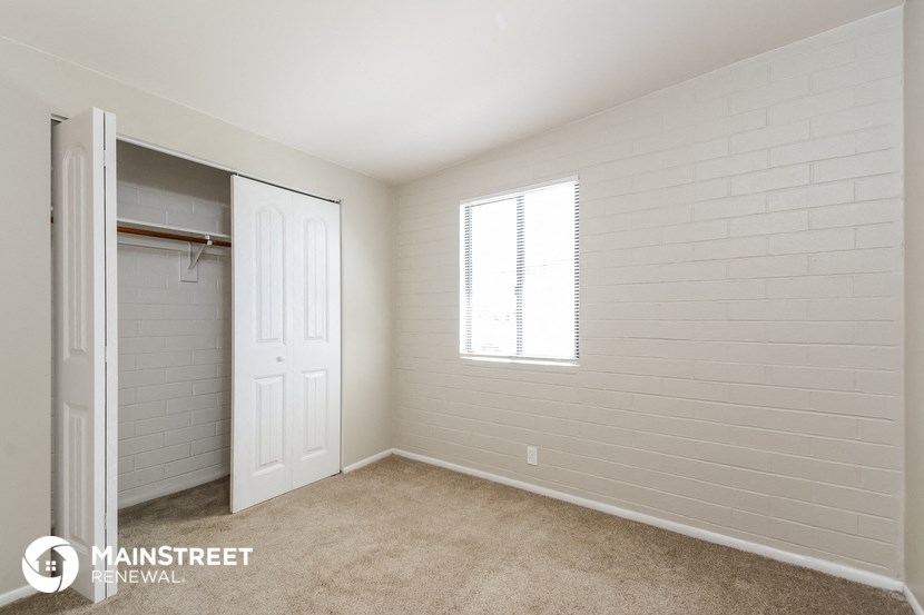 a bedroom with a closet and a door to a wardrobe