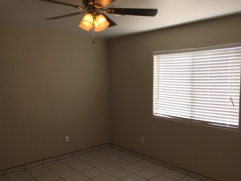 a living room with a ceiling fan and a window