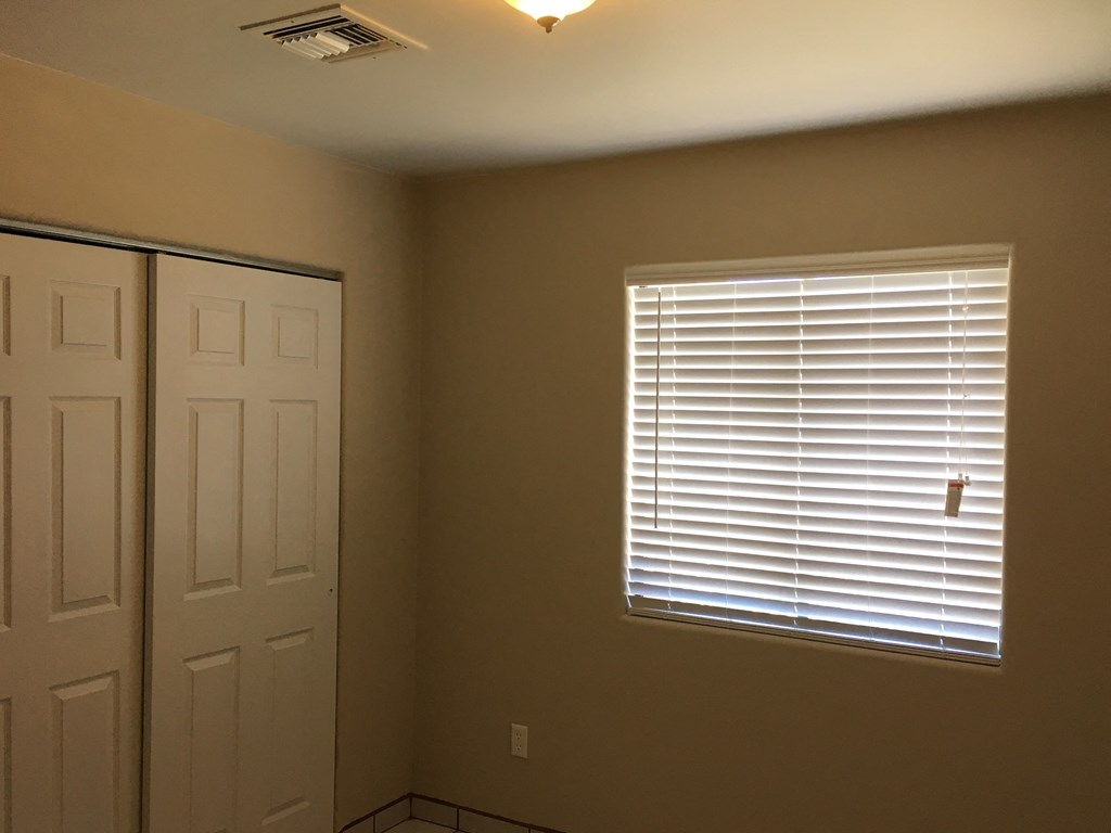 a room with a window and a door and a closet