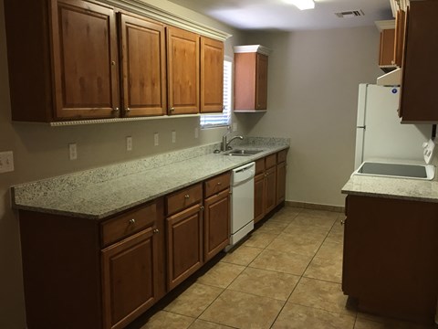 a kitchen with granite counter tops and wooden cabinets