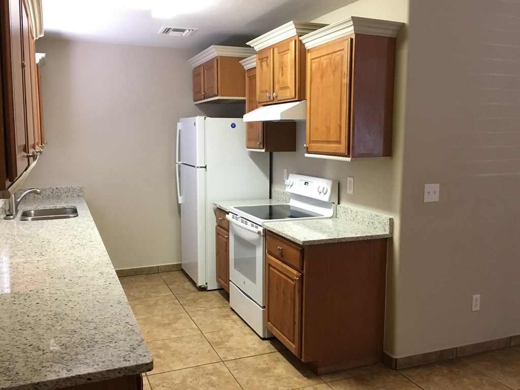 a kitchen with white appliances and wooden cabinets