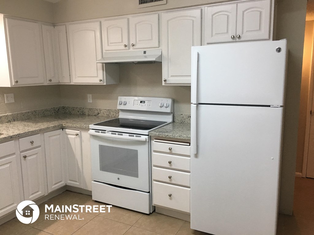 a white kitchen with white appliances and white cabinets